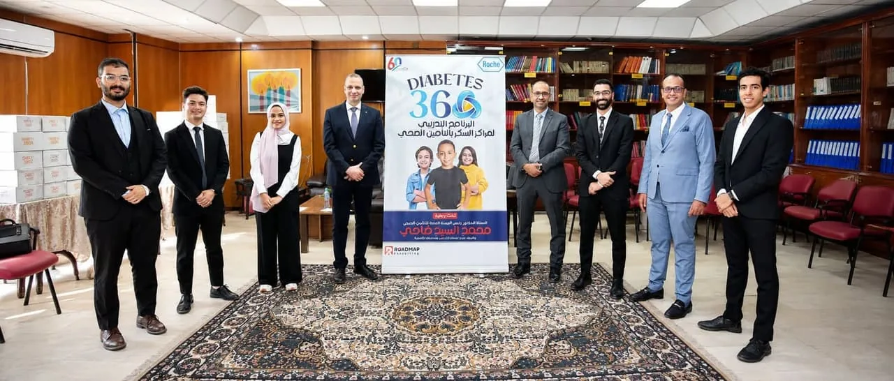 Roadmap Consulting and partner team members standing beside the Diabetes 360 program banner at an event venue